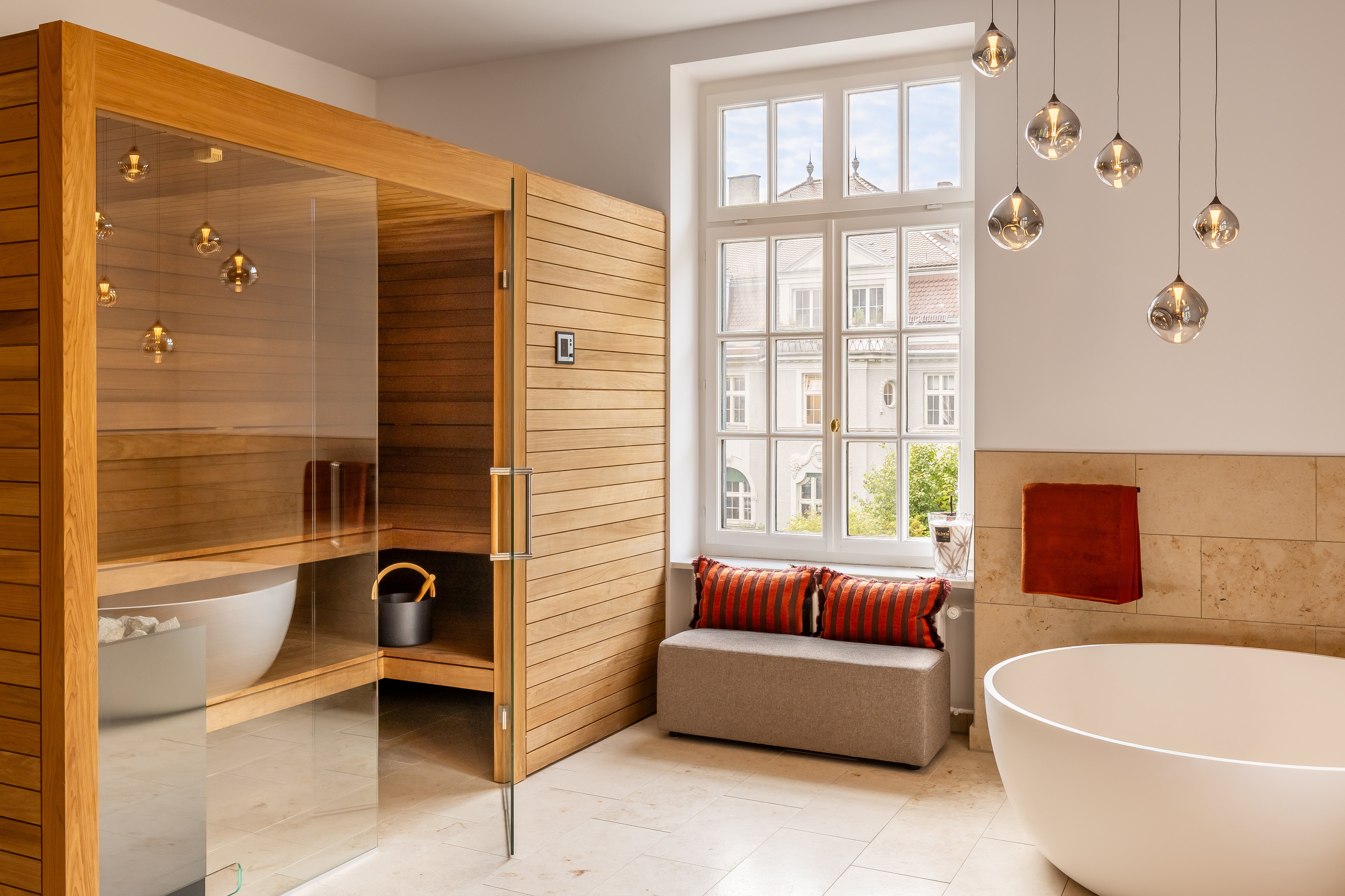 Bad mit Naturholz-Sauna und freistehender Wanne am Fenster