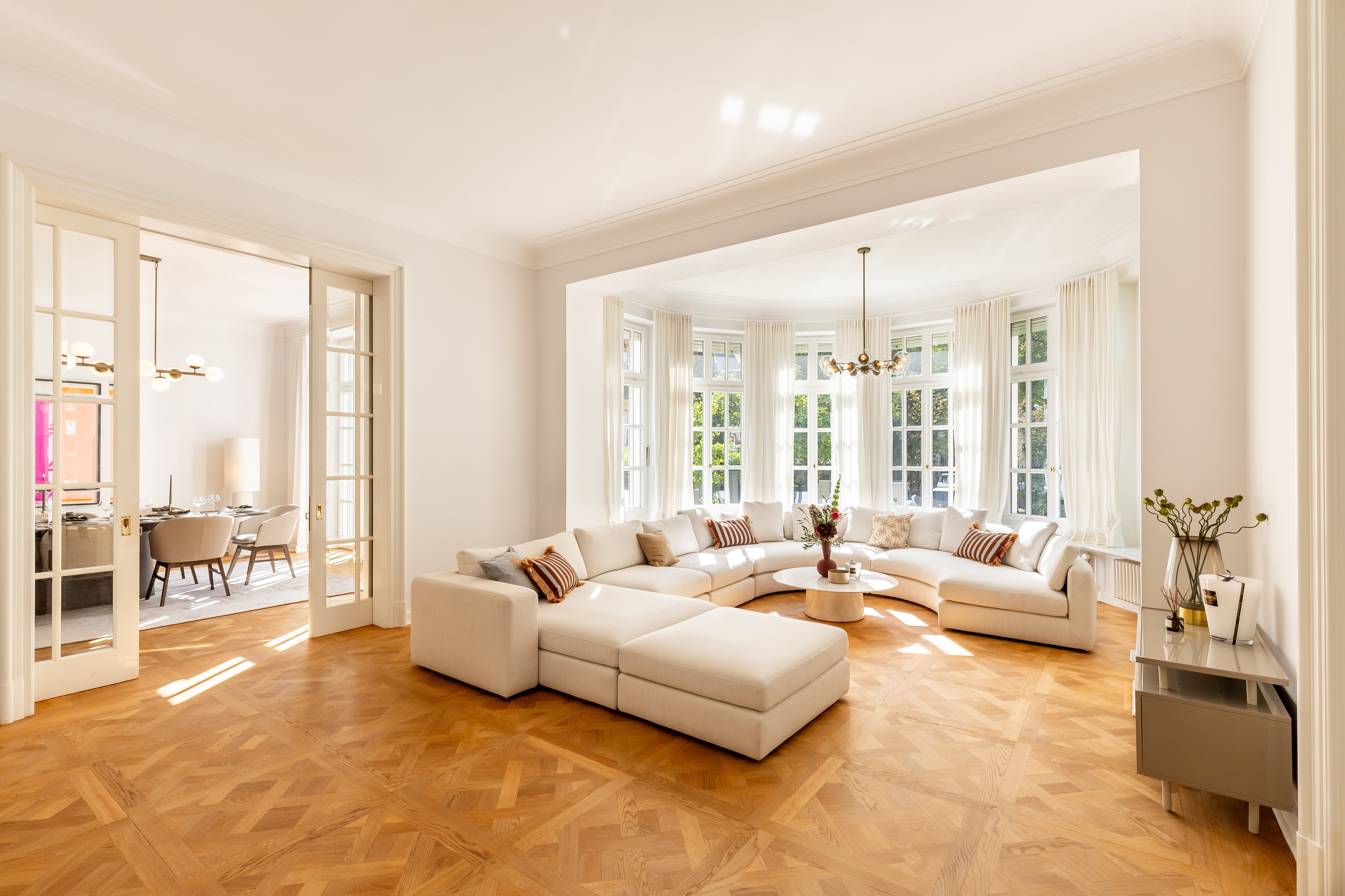 Lichtdurchflutetes Wohnzimmer mit runder Sofalandschaft in der Altbau-Villa Alt-Bogenhausen